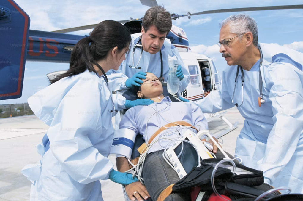 Two healthcare professionals practising CPR and defibrillation on a training mannequin
